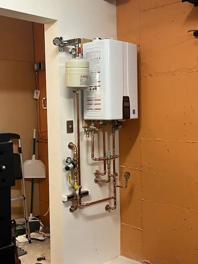 Plumbing technician inspecting water heater connections in North Laurel